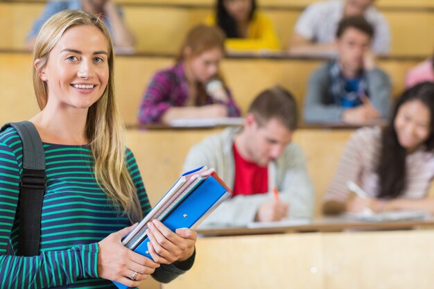 Zdjęcie uśmiechnięta kobieta z uczniami siedzi przy odczytową sala