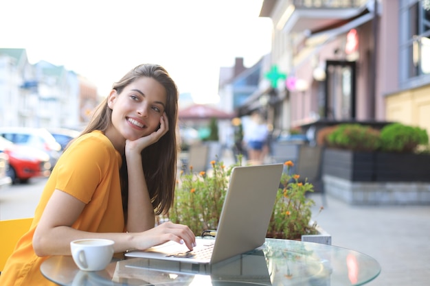 Uśmiechnięta Kobieta Za Pomocą Laptopa W Kawiarni. Pojęcie Przedsiębiorcy, Businesswoman, Freelancer.