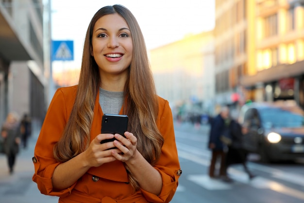 Uśmiechnięta kobieta za pomocą smartfona