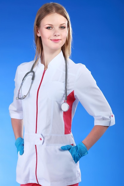 Uśmiechnięta kobiety lekarka z falcówką w jednolitej pozyci przy szpitalem