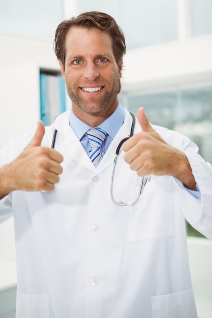 Uśmiechnięta lekarka gestykuluje aprobaty przy medycznym biurem