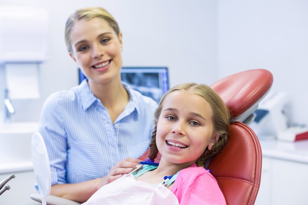Uśmiechnięta matka i córka w klinice stomatologicznej