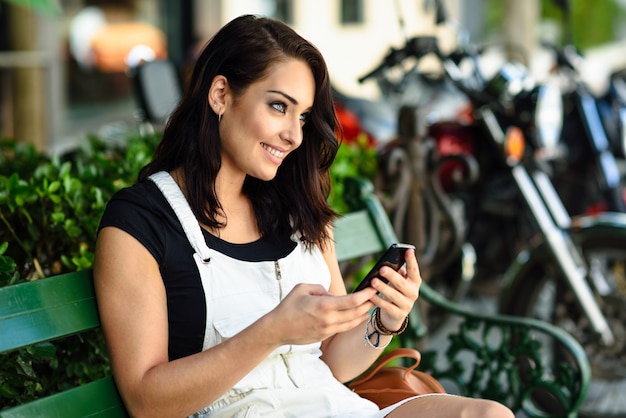 Uśmiechnięta Młoda Kobieta Używa Jej Mądrze Telefon Outdoors.