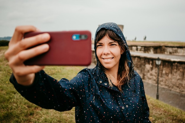 Zdjęcie uśmiechnięta młoda kobieta używająca telefonu komórkowego