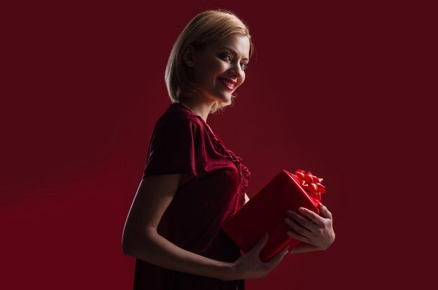 Uśmiechnięta młoda kobieta z pudełkiem szczęśliwa dziewczyna z prezentem