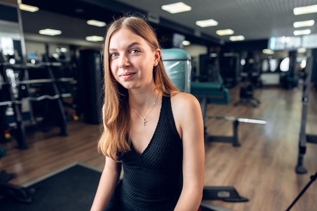 Uśmiechnięta nastolatka trenująca w klubie fitness