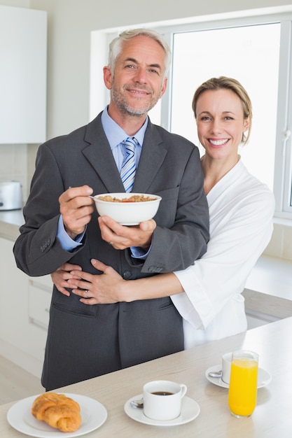 Uśmiechnięta para ma śniadanie w ranku przed pracą