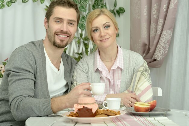 Zdjęcie uśmiechnięta para przy stole z kawą i jedzeniem