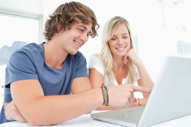 Uśmiechnięta para spojrzeć na laptopa razem