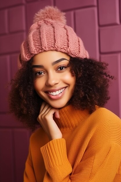 Uśmiechnięta piękna młoda Afroamerykanka ubrana w dzianinowy kapelusz i radośnie pozująca na kolorowym tle
