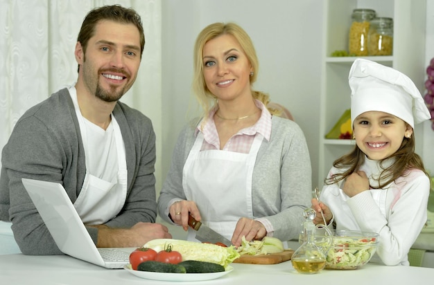 Uśmiechnięta rodzina je śniadanie przy stole w kuchni