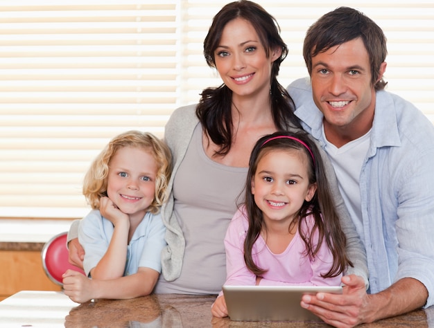 Uśmiechnięta rodzina używa wpólnie pastylka komputer
