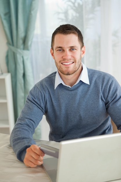 Uśmiechnięta samiec szczęśliwa o jego online zakupy