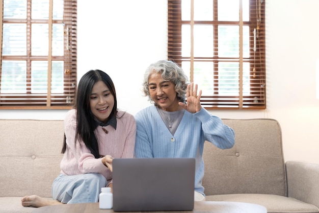 Uśmiechnięta starsza matka i dorosła córka korzystające z telefonu razem siedzące na wygodnej kanapie w domu szczęśliwa młoda kobieta i dojrzała mama patrzące na ekran smartfona oglądające wideo bawiące się dwa pokolenia