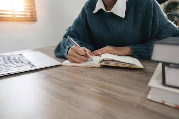 Uśmiechnięta studentka nosi słuchawki bezprzewodowe studiuj online z nauczycielem szczęśliwa młoda kobieta ucz się języka słuchaj wykładu oglądaj seminarium internetowe pisz notatki spójrz na laptopa edukacja na odległość