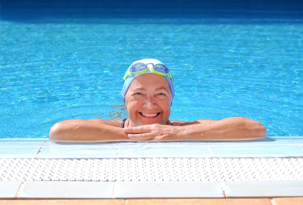 Uśmiechnięta Szczęśliwa Dojrzała Kobieta Na Brzegu Basenu Po Pływaniu W Czepku I Okularach