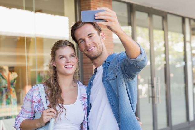 Uśmiechnięta szczęśliwa para bierze selfies