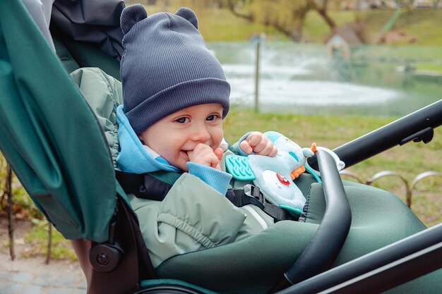 Zdjęcie uśmiechnięte dziecko w wózku dziecięcym w parku wiosennego