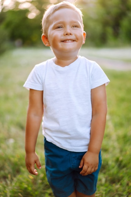 Uśmiechnięte dziecko z zabawką w letnim parku w słoneczny dzień Cute little boy korzystających z świeżej wiosennej pogody