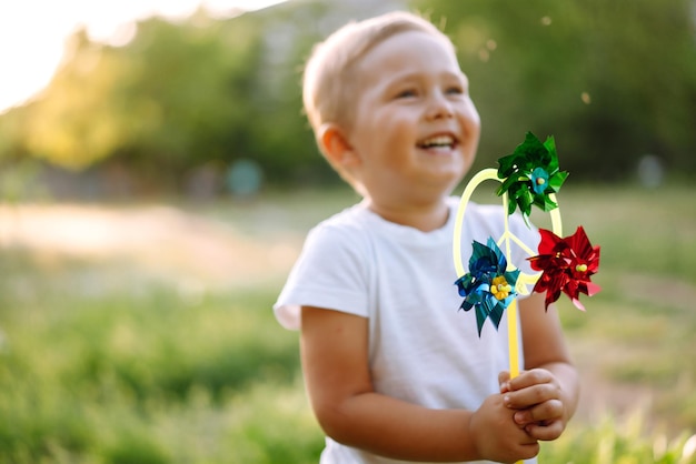 Uśmiechnięte dziecko z zabawką w letnim parku w słoneczny dzień Cute little boy korzystających z świeżej wiosennej pogody