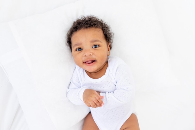 Uśmiechnięte małe afroamerykańskie dziecko w łóżeczku