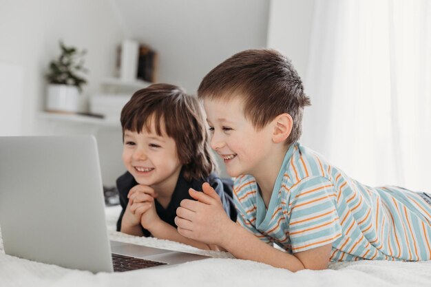 Zdjęcie uśmiechnięte rodzeństwo patrzące na laptop