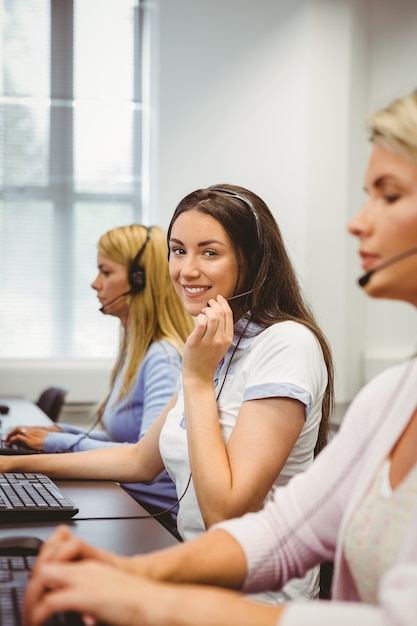 Uśmiechnięty agent call center rozmawia przez zestaw słuchawkowy