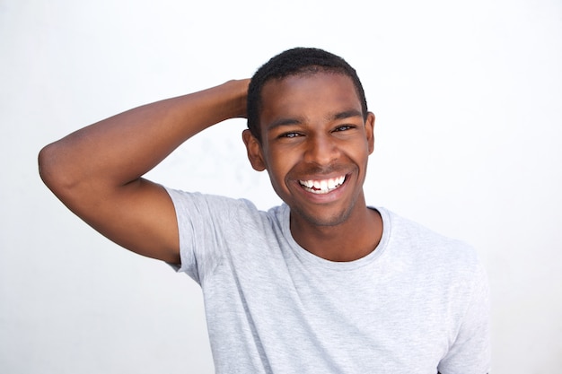 Uśmiechnięty amerykanina afrykańskiego pochodzenia facet z ręką w włosy