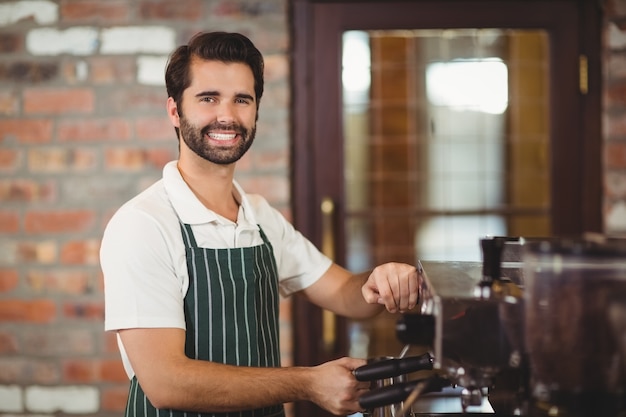 Uśmiechnięty barista przygotowuje kawę