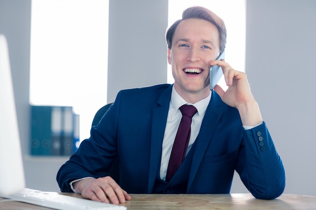 Uśmiechnięty biznesmen ma rozmowę telefonicza