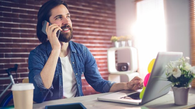 Uśmiechnięty biznesmen opowiada na telefonie