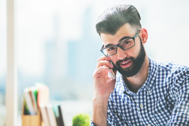 Uśmiechnięty biznesmen opowiada na telefonie