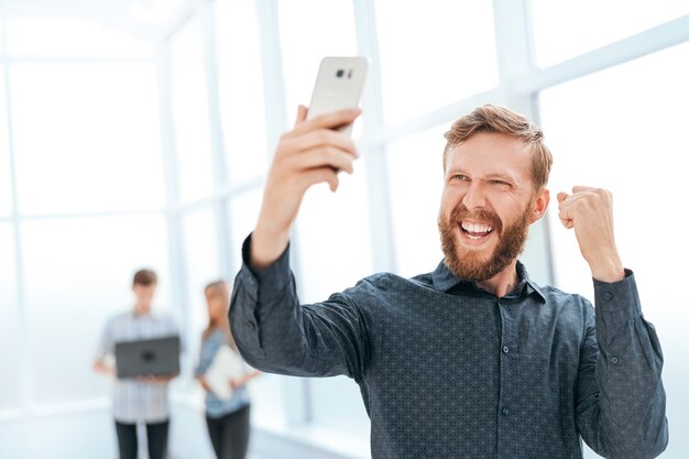 Uśmiechnięty biznesmen przy rozmowie wideo w holu urzędu