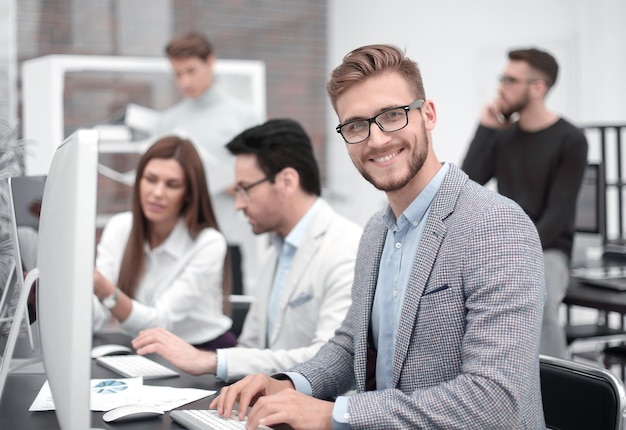 Uśmiechnięty biznesmen w ludziach i technologii w miejscu pracy