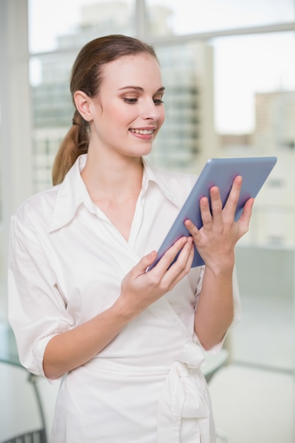 Uśmiechnięty bizneswoman trzyma jej pastylka komputer osobistego