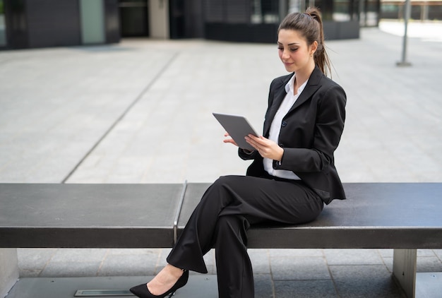 Uśmiechnięty bizneswoman używa cyfrową pastylkę plenerową