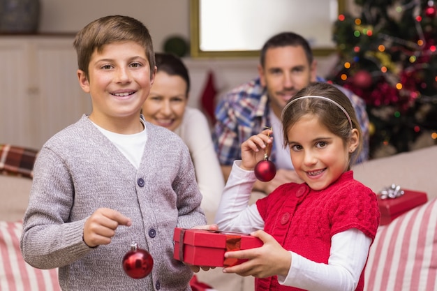 Uśmiechnięty brata i siostry mienia prezent i baubles