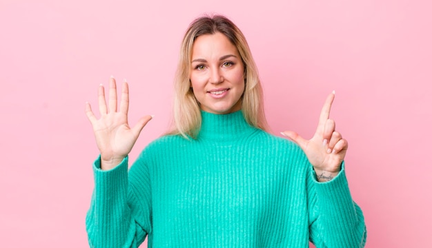 Uśmiechnięty I Wyglądający Przyjacielsko Pokazujący Numer Siedem Lub Siódmy Z Ręką Odliczającą W Dół