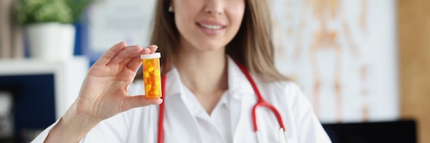 Uśmiechnięty Lekarz Medycyny Rodzinnej Trzyma I Daje Pacjentowi Słoik Tabletek