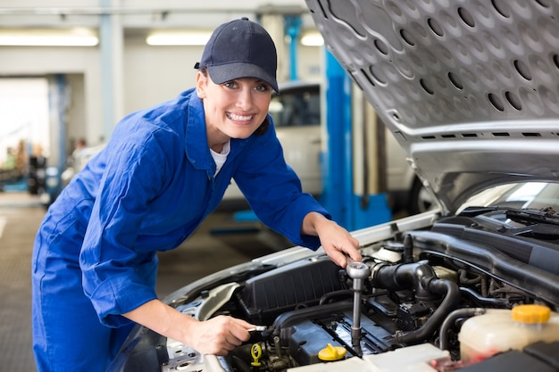 Uśmiechnięty mechanik pracuje na samochodzie