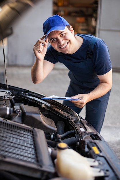 Uśmiechnięty mechanik trzyma schowek