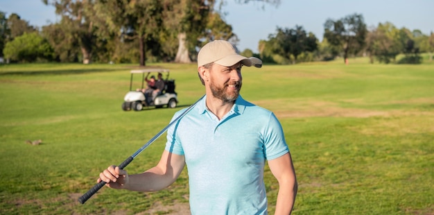 Uśmiechnięty mężczyzna golfista na profesjonalnym polu z zieloną trawą, lato.