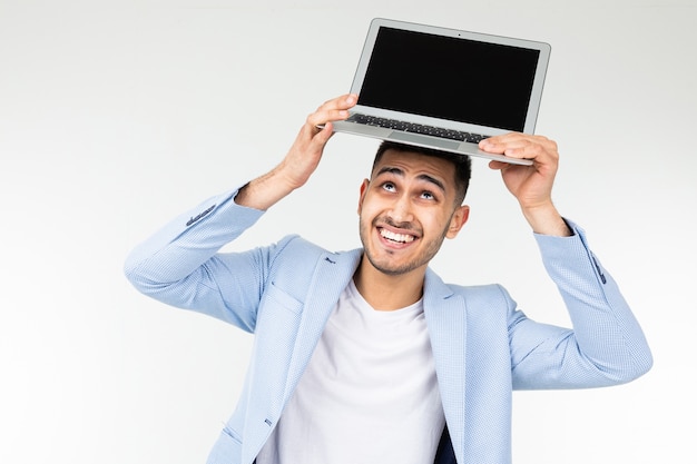 Uśmiechnięty młody brunetka mężczyzna trzyma laptopu ekran kamera z pustym mockup na białym tle