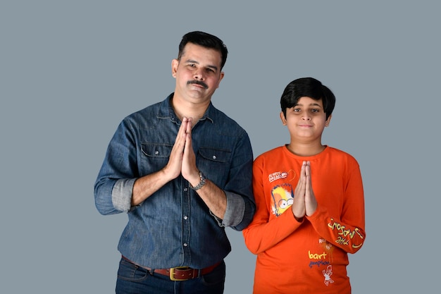 uśmiechnięty młody ojciec i syn patrzą na aparat pozujący indyjski pakistański model