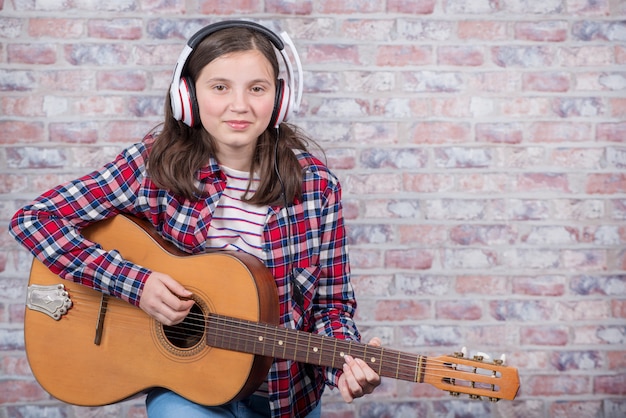 Uśmiechnięty nastolatek gra na gitarze