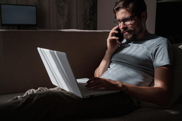 Uśmiechnięty przystojny freelancer pracujący zdalnie z domu