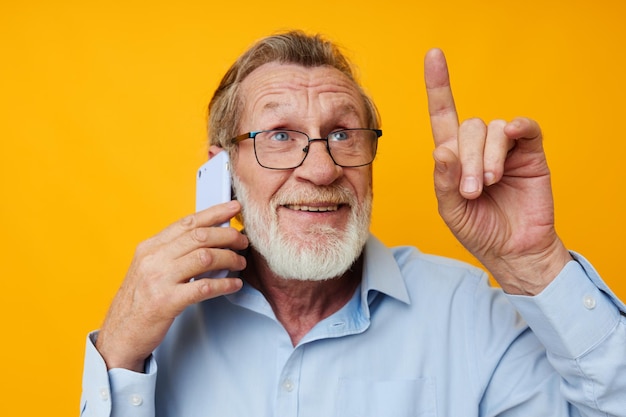 Zdjęcie uśmiechnięty starszy mężczyzna gestuje podczas rozmowy przez telefon