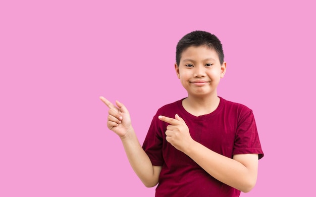 Uśmiechnięty szczęśliwy azjatycki chłopiec wskazujący palcem na miejsce na kopię na białym tle na prostym tle