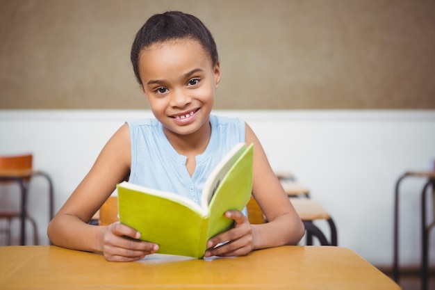 Uśmiechnięty uczeń czyta książkę