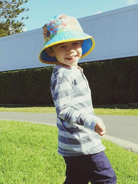 Zdjęcie uśmiechnięty uroczy chłopiec stojący na drodze